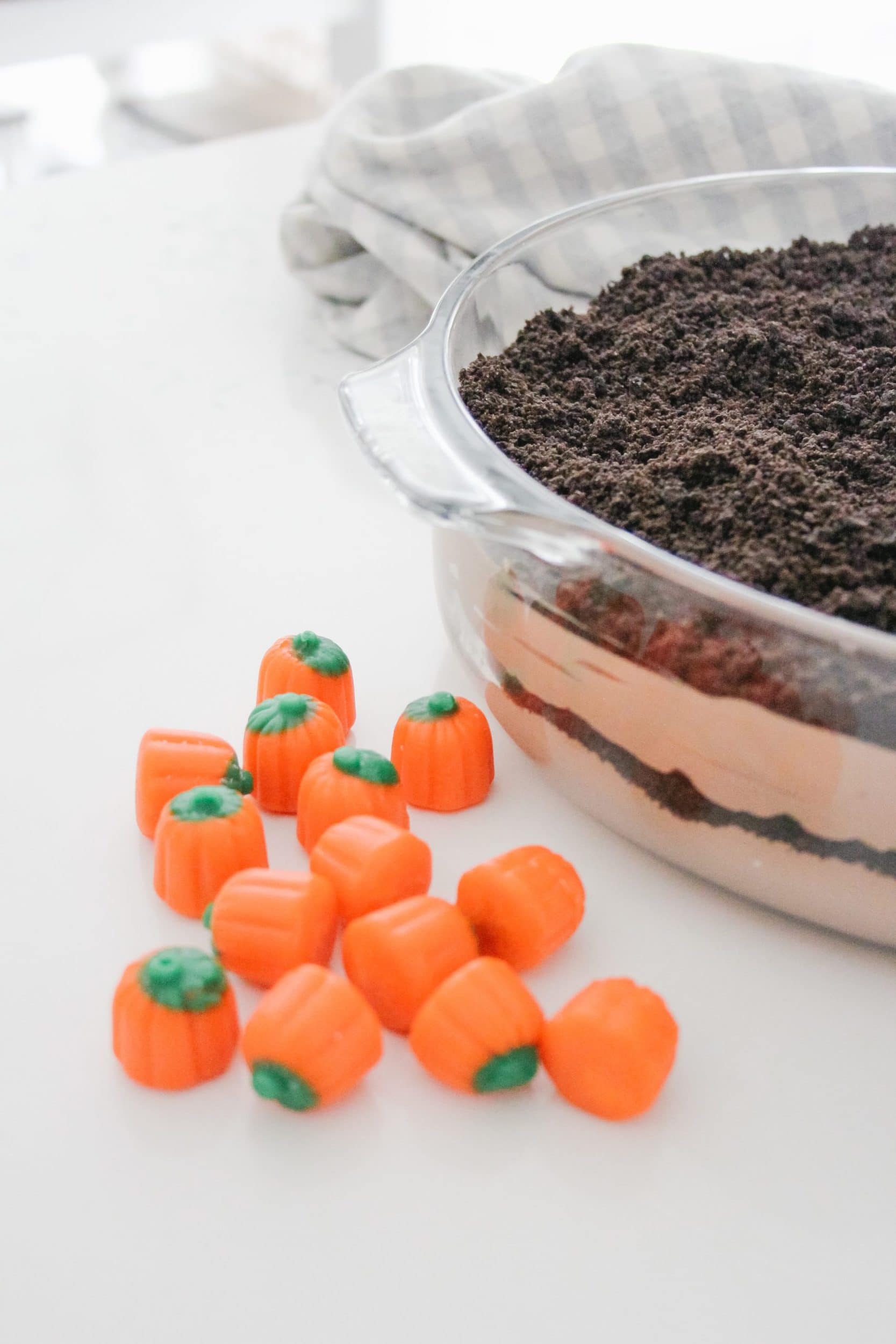 layered dirt pudding in a clear casserole dish with candy corn pumpkins 