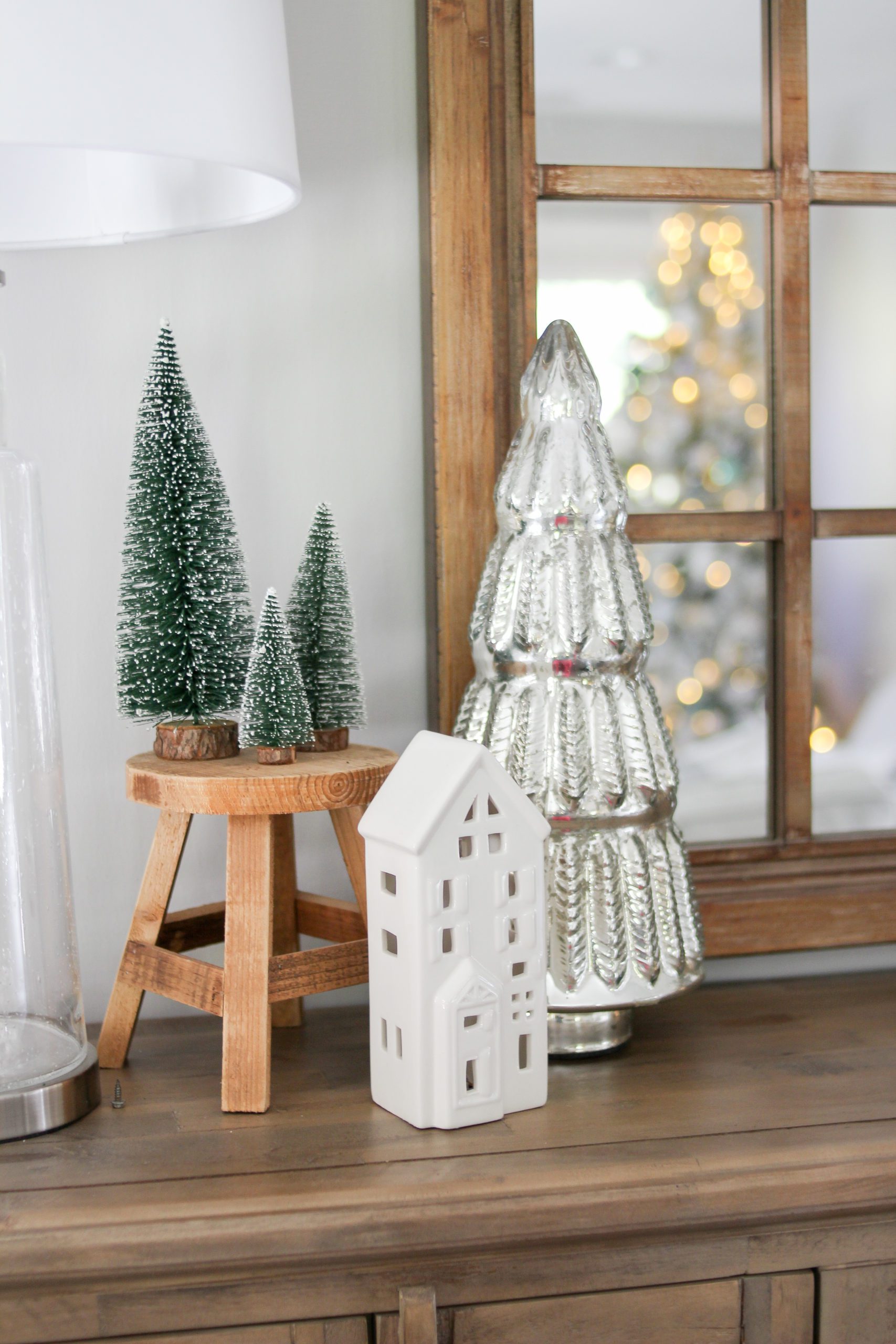 white ceramic christmas village tree, green flocked bottle brush trees on a plant stand, mercury glass christmas tree, christmas tree light reflection