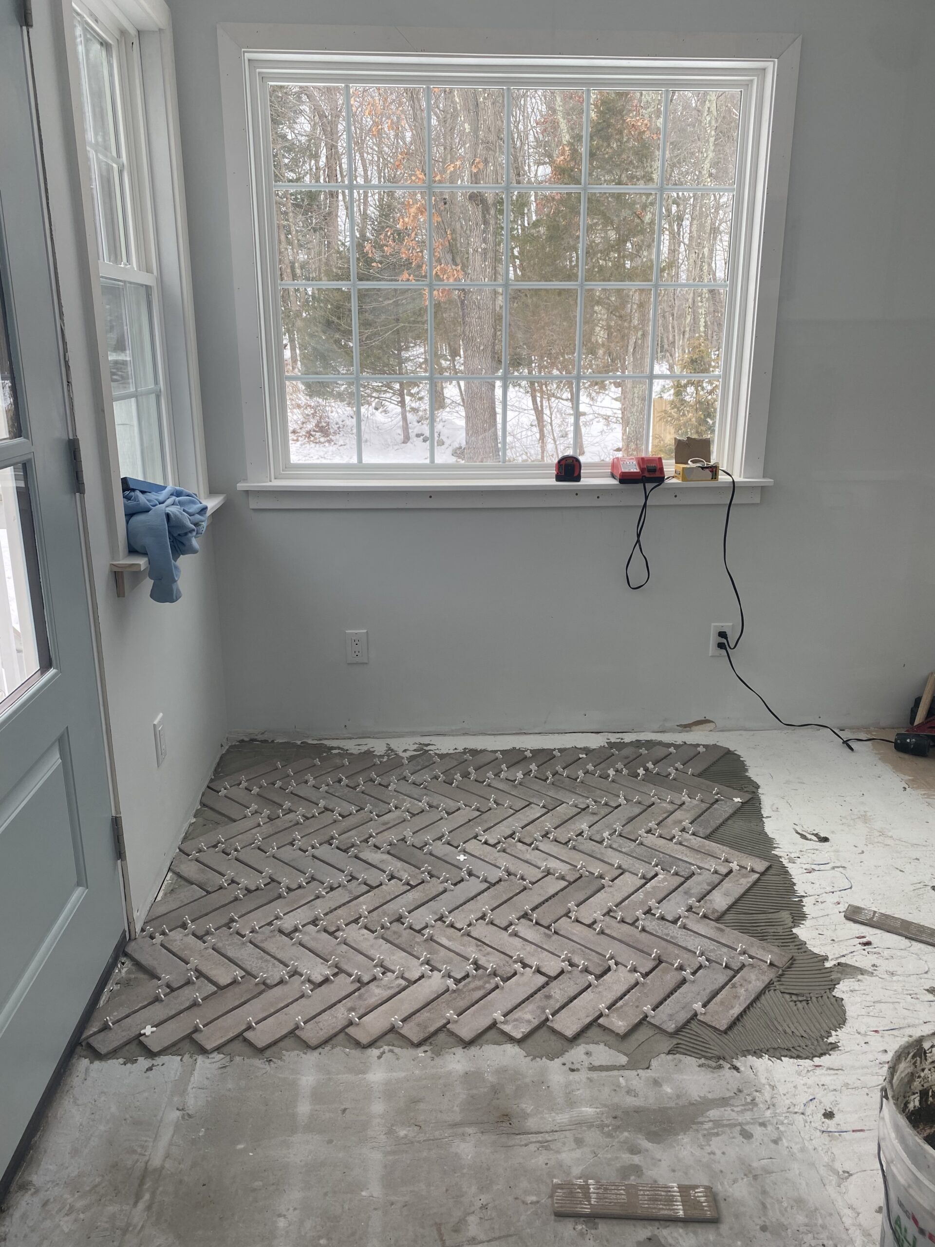 herringbone tile being installed on top of radiant flooring